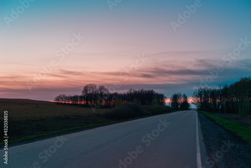 Road and forest at sunset.