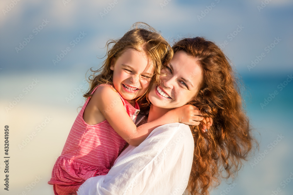 Portrait of happy mother and little daughter on sunny beach on Maldives at summer vacation Portrait of happy mother and little daughter on sunny beach on Maldives at summer vacation