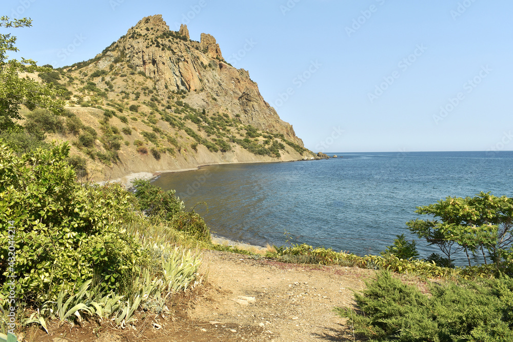 landscape with a bay and a mountain whose slope descends into the sea
