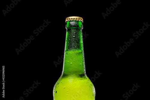 Green beer bottle on black background. Cold and refreshing beer