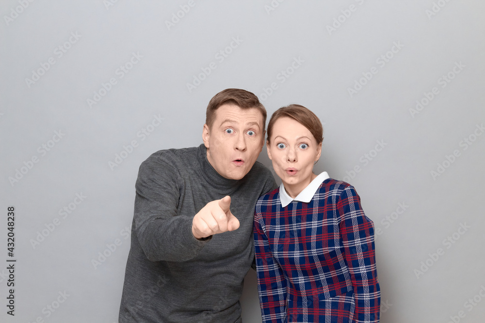 Portrait of surprised couple, man is pointing with finger at something Portrait of surprised couple, man is pointing with finger at something