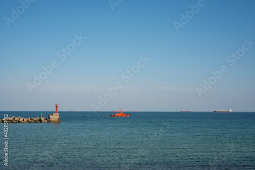 An orange pilot boat goes to the outer roadstead to ensure the escort of the vessel to the port.