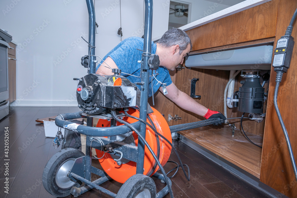 Fototapeta premium Plumber drain cleaning on kitchen sink
