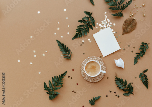 Flat lay coffee cup and blank card over brown background. Top view, copy space. Blogger or magazine concept