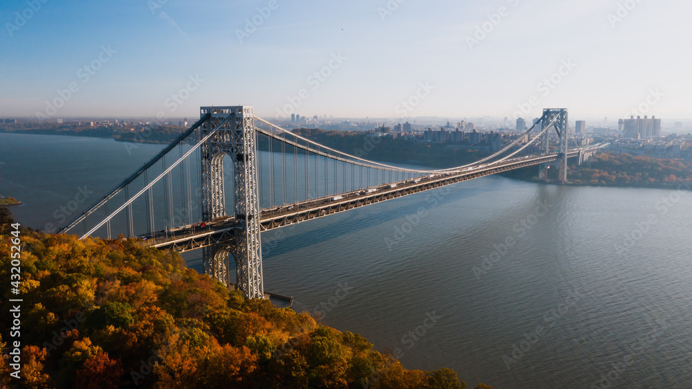 Aerial of George Washington Suspension Bridge over Hudson River at Autumn Sunrise - Interstate 95, US Route 1 & 9 - Fort Lee, New Jersey & Bronx, New York City, New York