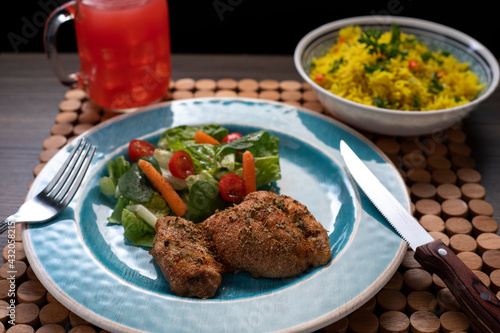 Roasted chicken thigh with zafrani rice and salad photo