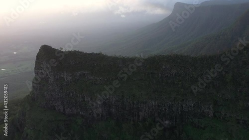 Aerial reveal shot of the big famous Pinnacle Point at Border Ranges National Park, New South Wales in Australia. Drone shot going backwards and beautiful landscape in the background. photo