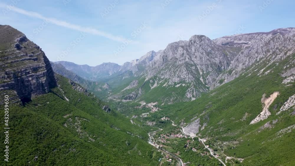 Aerial drone view of village and river canyon. Green forest in early spring. Hills and mountain range. Dreznica and Drezanka in Bosnia and Herzegovina. Aerial drone view of village and river canyon. Green forest in early spring. Hills and mountain range. Dreznica and Drezanka in Bosnia and Herzegovina.