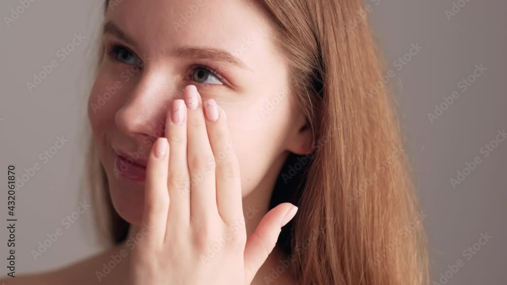 Skin care. Pretty woman. Sensitive skin treatment. Morning routine. Delicate cosmetic. Fair hair lady tenderly applying under eye cream isolated beige. Skin care. Pretty woman. Sensitive skin treatment. Morning routine. Delicate cosmetic. Fair hair lady tenderly applying under eye cream isolated beige.