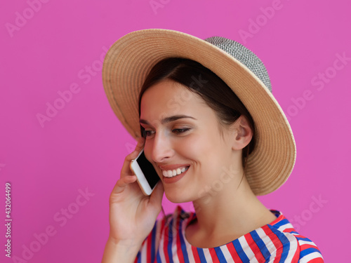 Portrait of young girl with happy face while using smartphone isolated on pink background