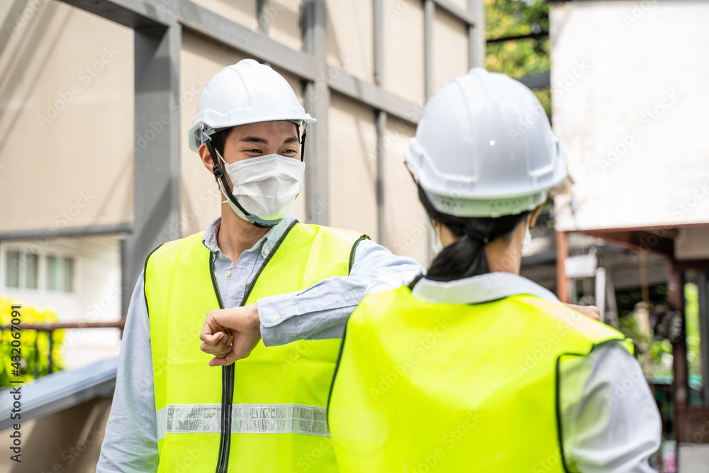 Asian young male and female engineer greeting each other by elbow bump Asian young male and female engineer greeting each other by elbow bump