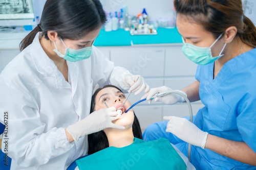 Asian dental team providing oral treatment service in dental clinic.