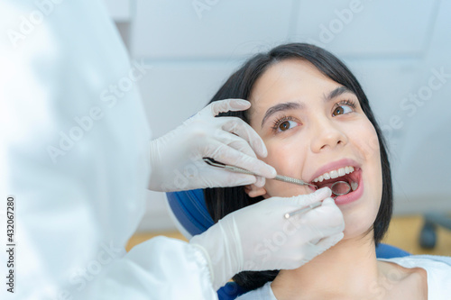 Close-up shot of female patient getting tooth checkup in dental clinic