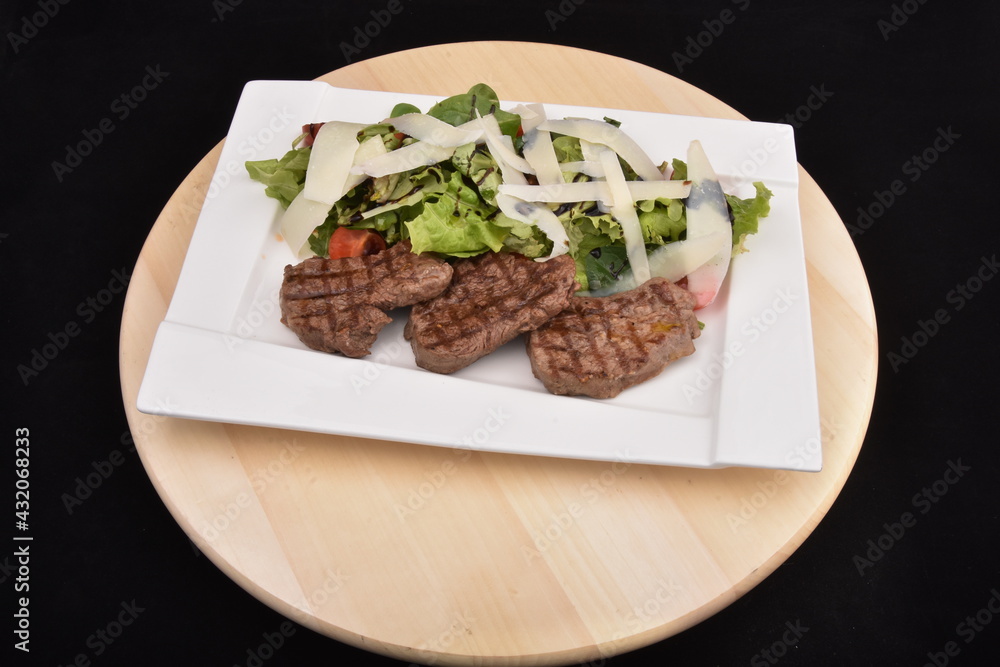 Grilling steaks  with salad and  Parmesan cheese