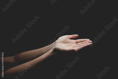 A woman hand pray to god over the dark background. 
