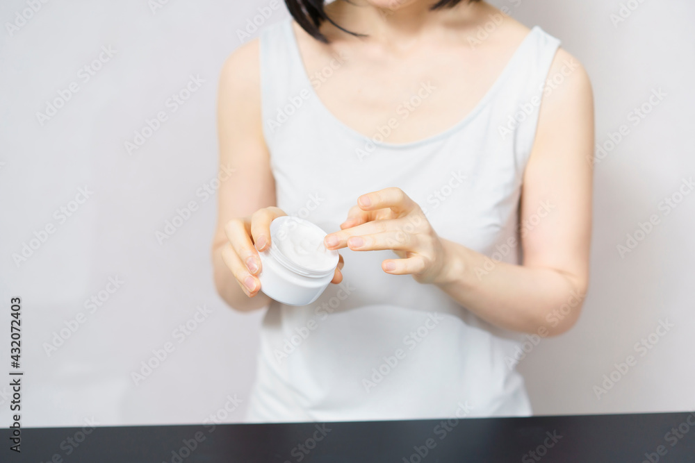 クリームを手に取る中年女性
