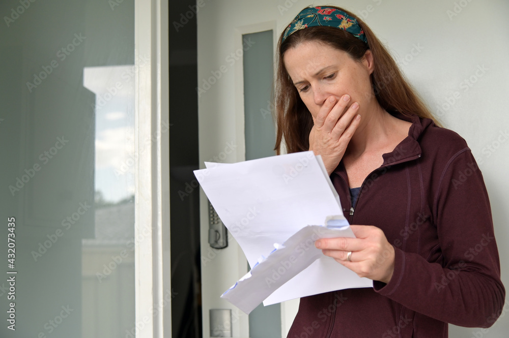 Shocked woman reading a letter