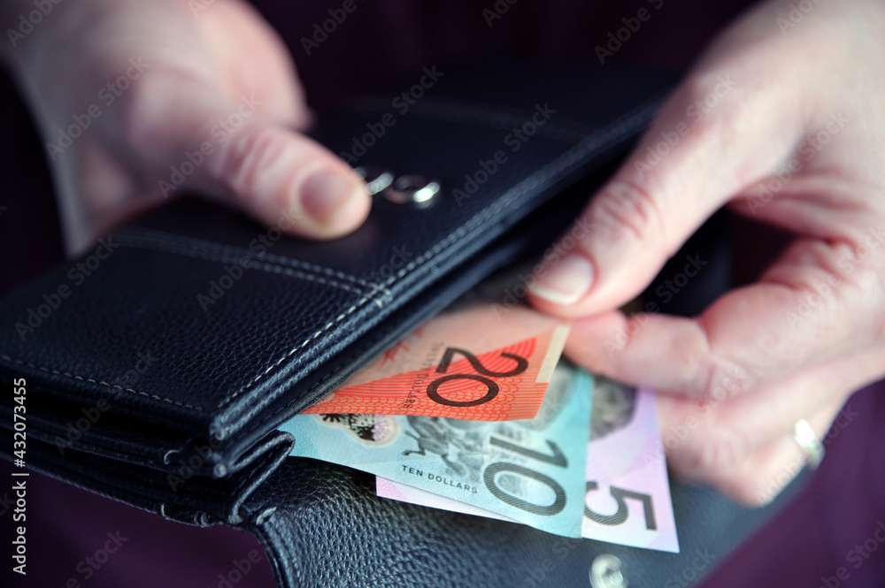Woman hand pulling out Australian money from a wallet
