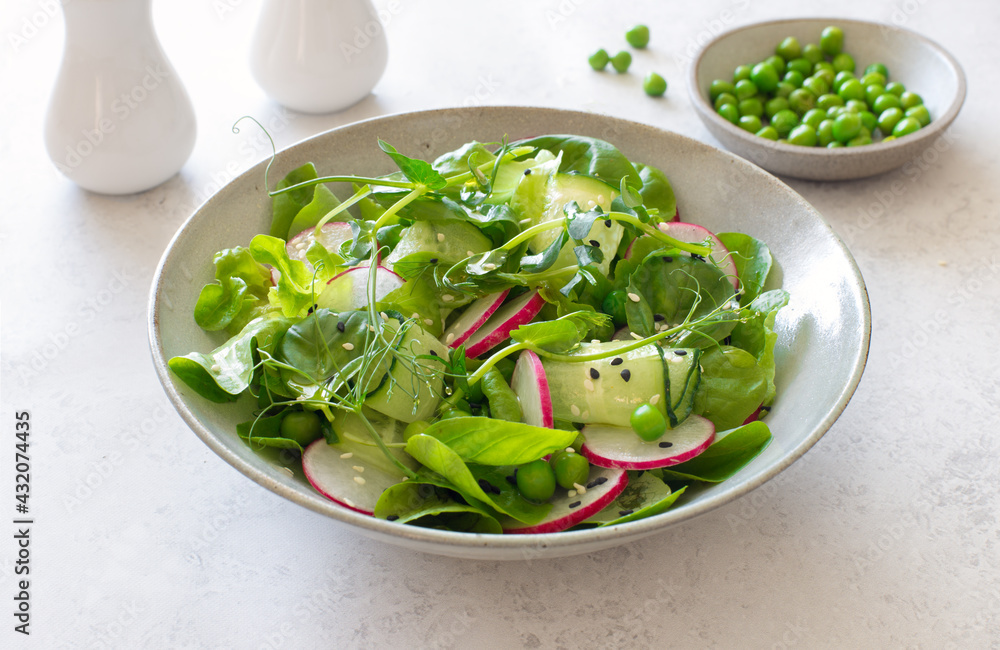Radish, cucumber, green peas and mixed salad leaves spring salad close up Radish, cucumber, green peas and mixed salad leaves spring salad close up