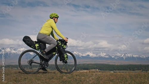 The man travel on mixed terrain cycle touring with bikepacking. The traveler journey with bicycle bags. Sport tourism bikepacking. photo