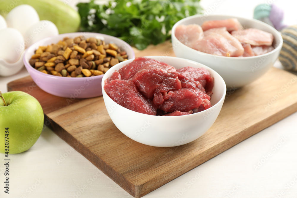 Natural pet food on white wooden table, closeup Natural pet food on white wooden table, closeup