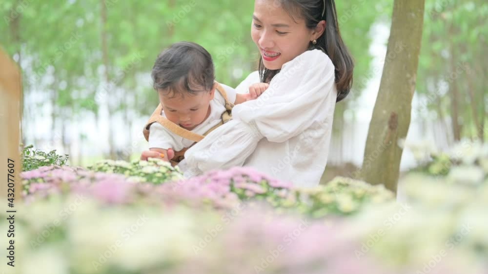 mother with little child in white blooming garden. woman with son in green leaves,happy family outdoors in spring mother with little child in white blooming garden. woman with son in green leaves,happy family outdoors in spring