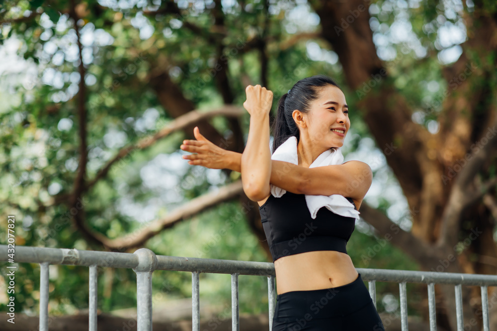 Portrait of beautiful healthy young woman warming up and exercising outdoors in the park. stretching arms and legs Portrait of beautiful healthy young woman warming up and exercising outdoors in the park. stretching arms and legs