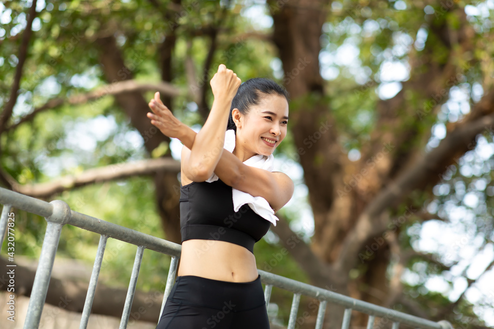 Portrait of beautiful healthy young woman warming up and exercising outdoors in the park. stretching arms and legs Portrait of beautiful healthy young woman warming up and exercising outdoors in the park. stretching arms and legs
