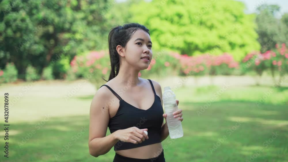 Portrait of Asian young beautiful woman wearing black t-shirt drinking water at summer green park.
Portrait of Asian young beautiful woman wearing black t-shirt drinking water at summer green park.