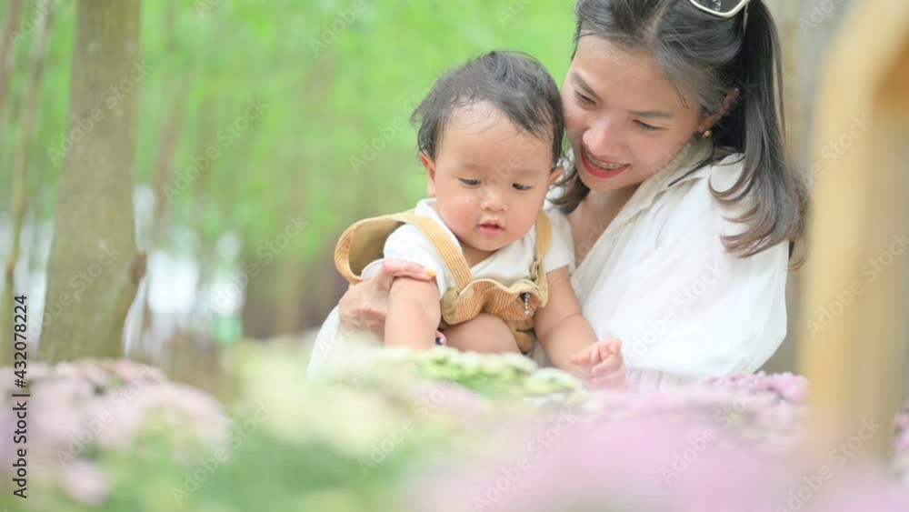 mother with little child in white blooming garden. woman with son in green leaves,happy family outdoors in spring mother with little child in white blooming garden. woman with son in green leaves,happy family outdoors in spring