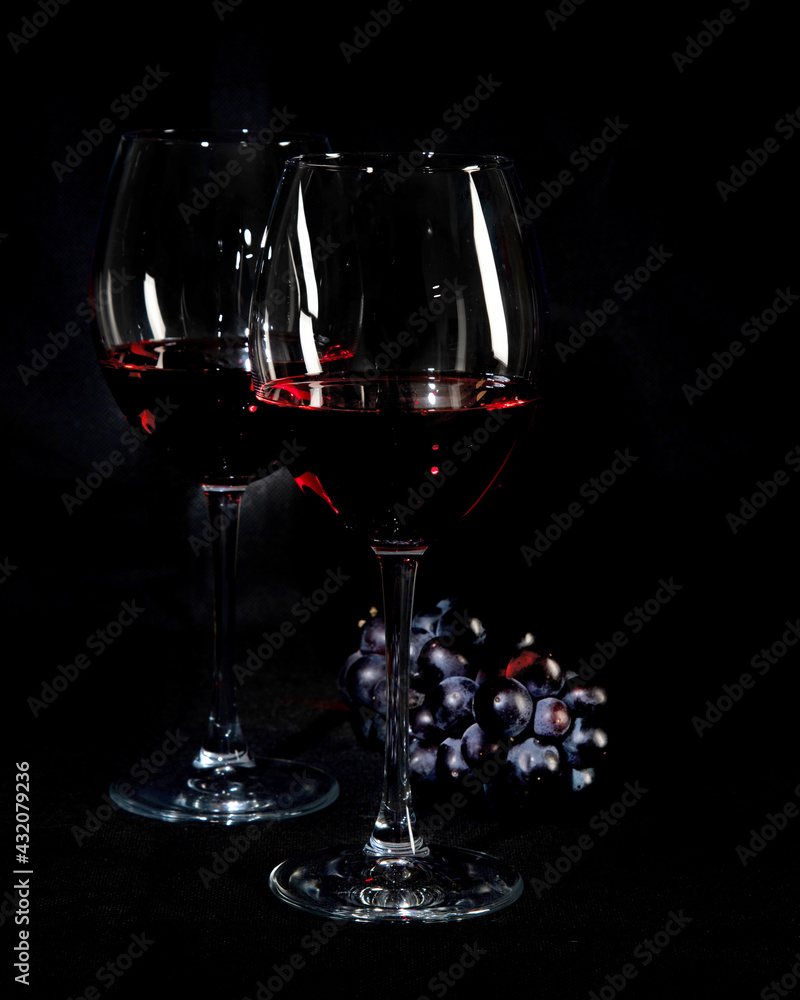 Red wine bottle with 2 glasses and bottle opener on black background. - obrazy, fototapety, plakaty 