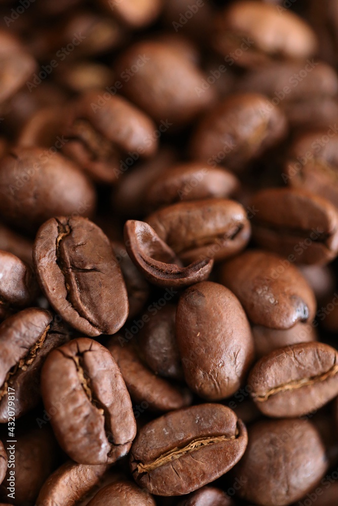 Naklejka premium Coffee beans background. Roasted coffee close-up.Texture of coffee beans. space for text.Arabica coffee variety.Traditional morning drink