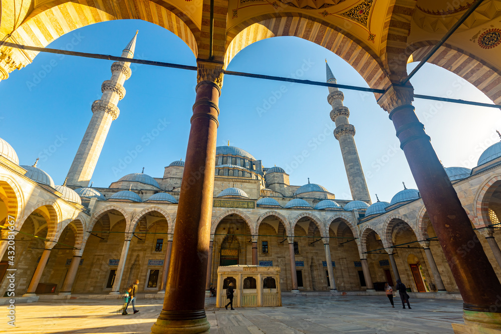 Picturesque architecture of north facade of ancient Suleymaniye Mosque with forecourt and central fountain in Istanbul on sunny day, Turkey.. - obrazy, fototapety, plakaty 