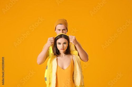 Stylish young couple on yel...