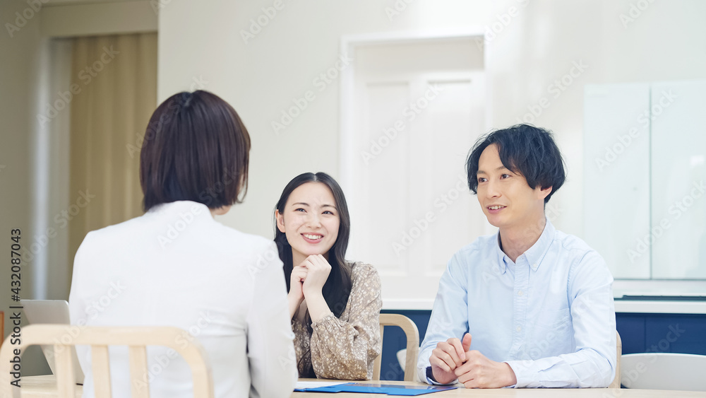 Fototapeta premium カップルと面談する女性 セールスウーマン ライフプランナー