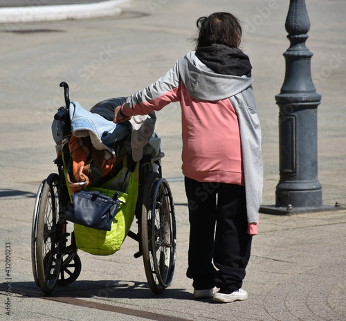 Homeless woman with a wheelchair on the street photo