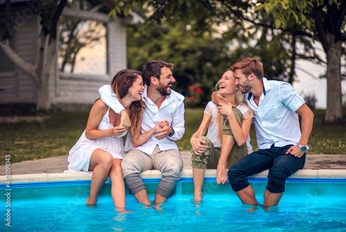 Friends having fun by the pool. © liderina