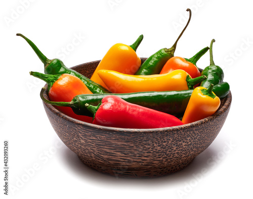 Wooden bowl full of Chili or sweet peppers isolated on white background