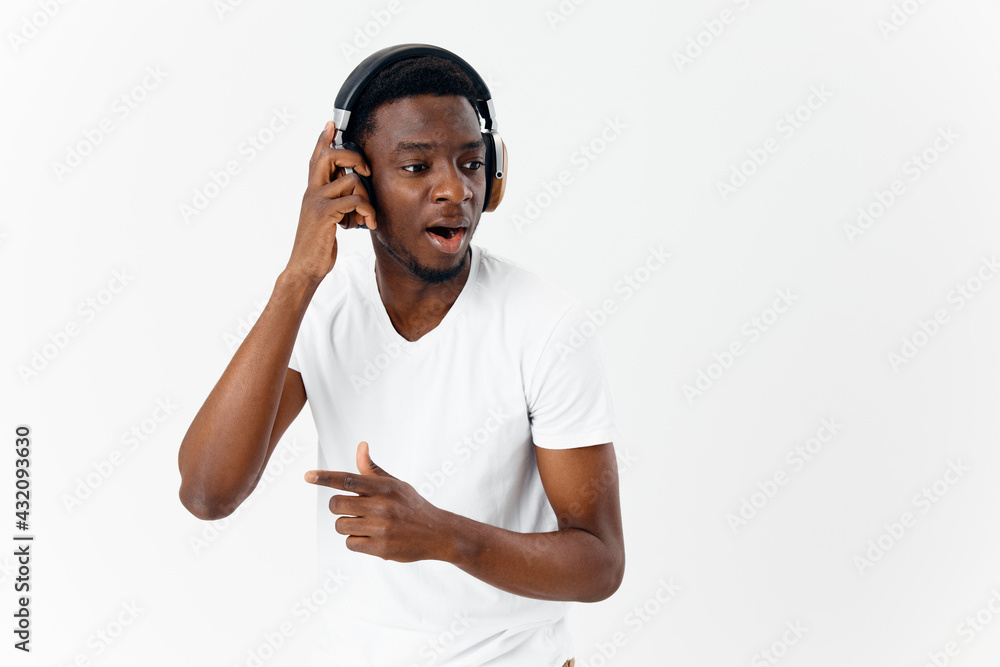 Naklejka premium man of African appearance listens to music with headphones emotions