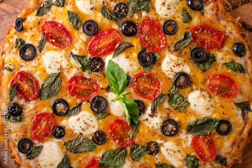 Italian pizza with olives, mozzarella, basil.Closeup.Texture