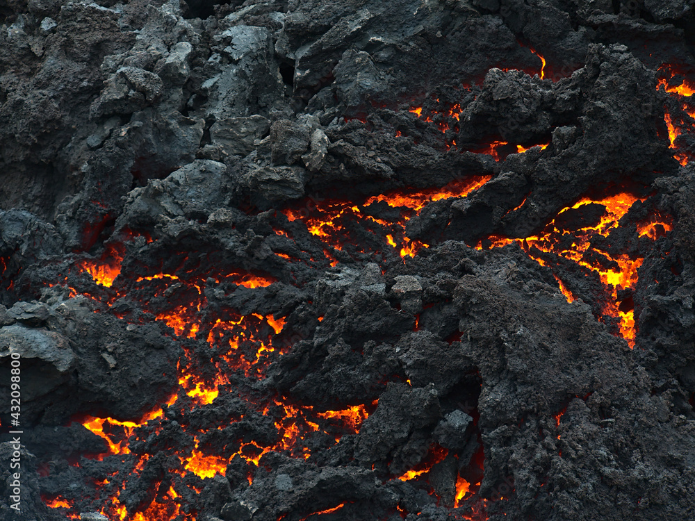 Closeup view of cooling down lava rocks with orange glow after the eruption of a volcano in Geldingadalir valley near Fagradalsfjall mountain, Grindavík, Reykjanes peninsula, southwest Iceland. Closeup view of cooling down lava rocks with orange glow after the eruption of a volcano in Geldingadalir valley near Fagradalsfjall mountain, Grindavík, Reykjanes peninsula, southwest Iceland.