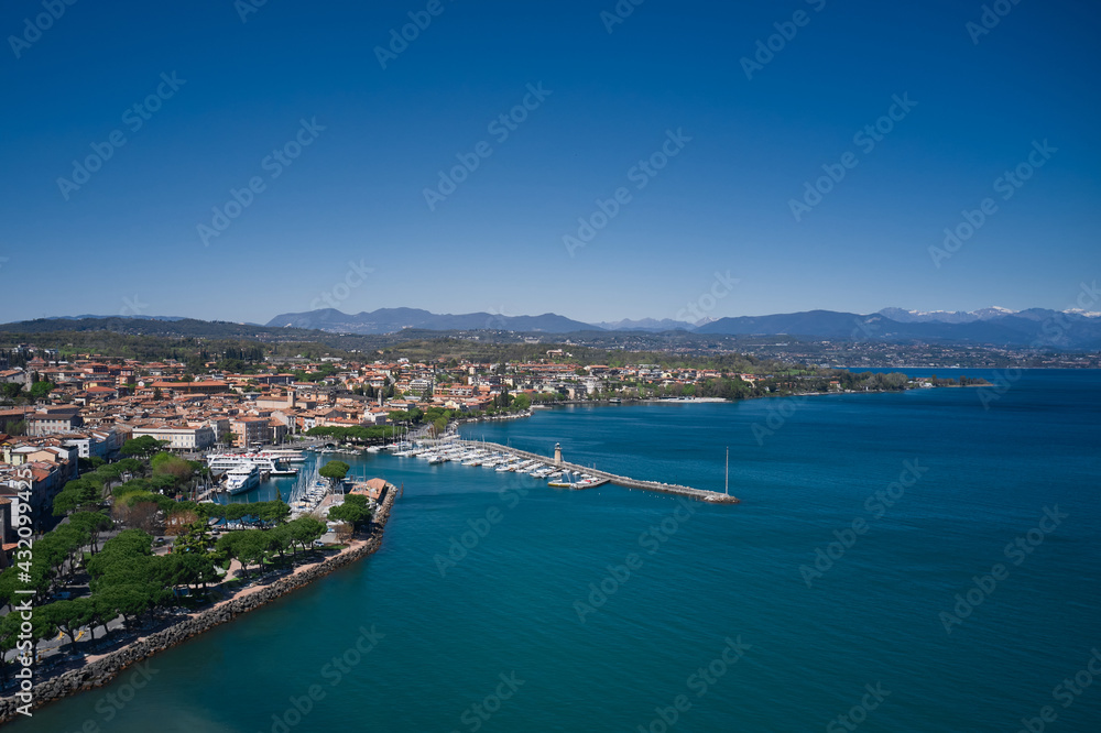 Aerial view of the coastline of the city of Desenzano del Garda on Lake Garda, Italy. Desenzano del garda port. Aerial panorama of Italian cities.