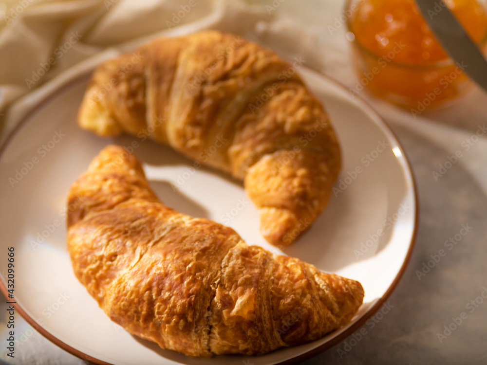 Morning breakfast. Croissants with coffee and jam. On a light table