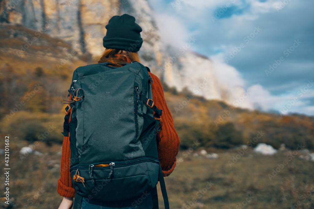 woman hiker with a backpack travels in the mountains outdoors in autumn fallen leaves woman hiker with a backpack travels in the mountains outdoors in autumn fallen leaves