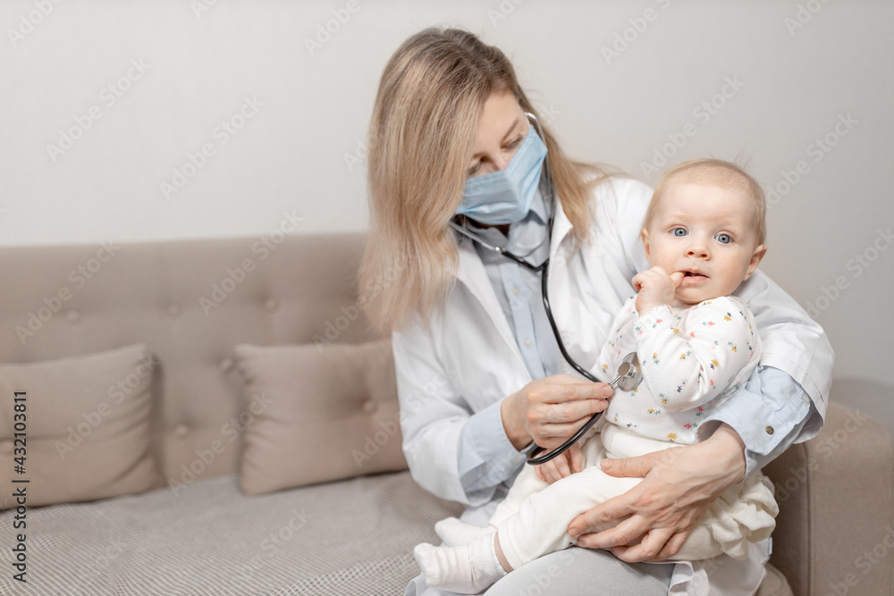Woman doctor in blue mask doing a month checkup of little girl hold a stethoscope. Female pediatrician examining cute toddler, checks heart and lungs of adorable baby. Health care concept