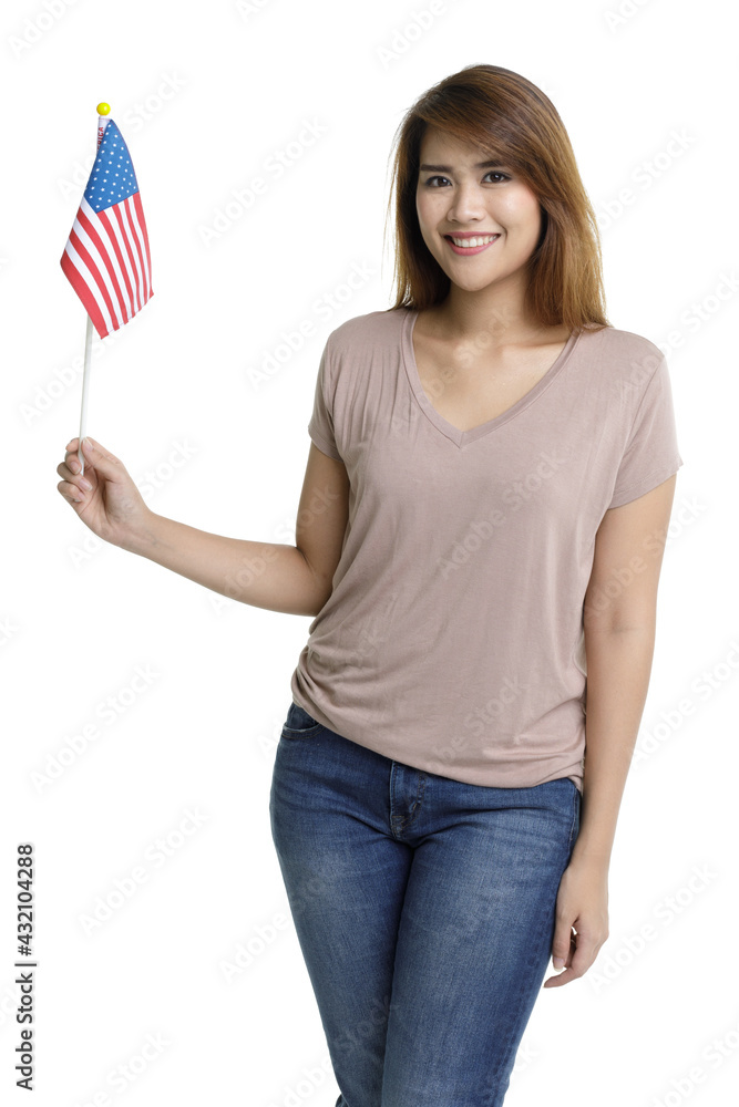 Isolated portrait shot of Asian young beautiful long brown hair woman in casual shirt and jeans stand smile look at camera holding small United States national flag on white background Isolated portrait shot of Asian young beautiful long brown hair woman in casual shirt and jeans stand smile look at camera holding small United States national flag on white background