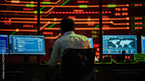 Professional IT Technical Support Specialists and Software Developer Working on Computers in Monitoring Control Room with Digital Screens with Server Data, Blockchain Network and Surveillance Maps. 
