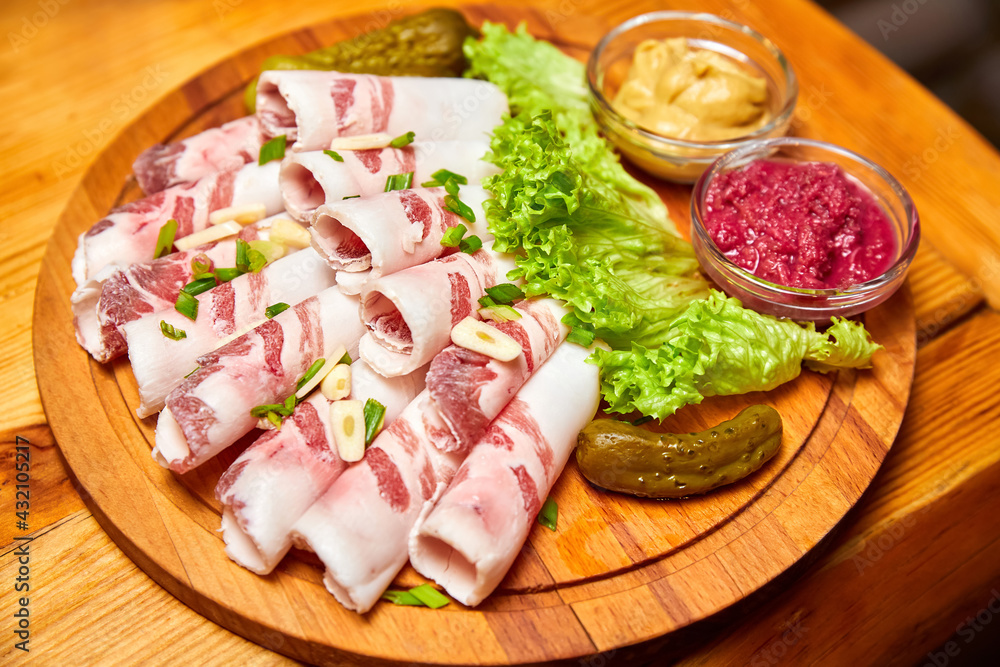 Lard with garlic, mustard and horseradish on a wooden board. Close-up, selective focus Lard with garlic, mustard and horseradish on a wooden board. Close-up, selective focus