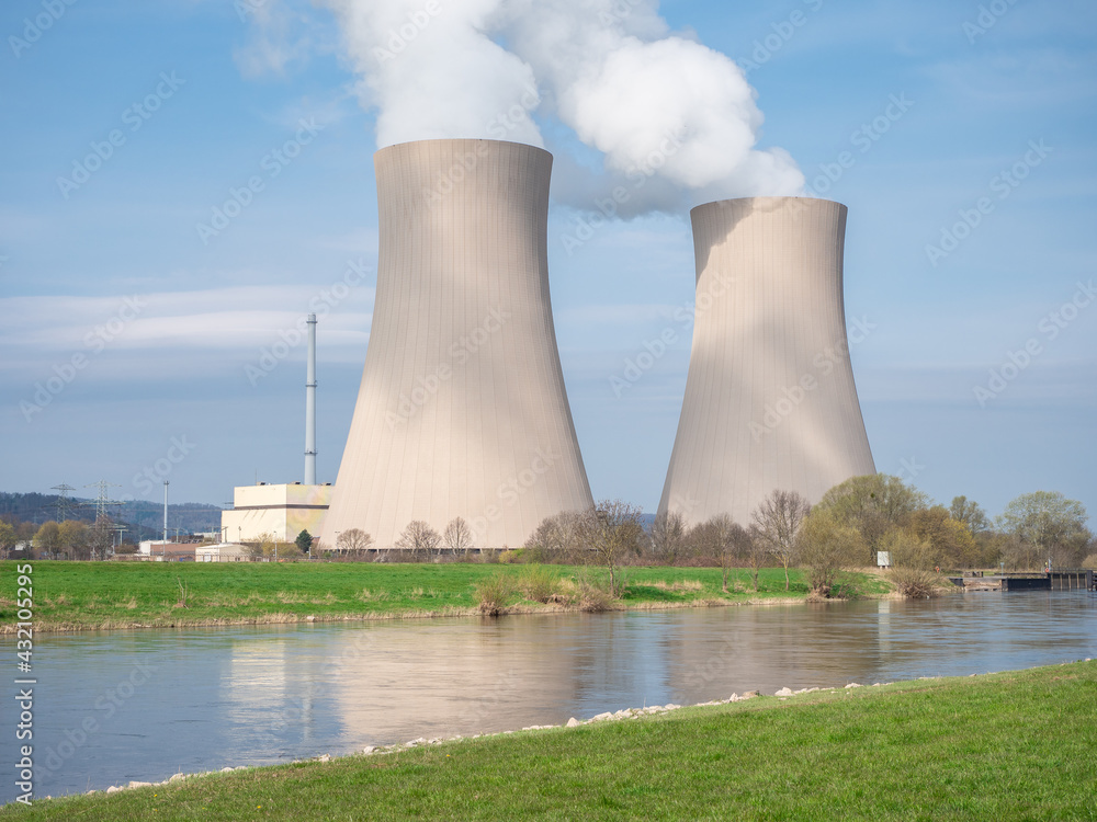 Nuclear power plant against sky by the river at sunset