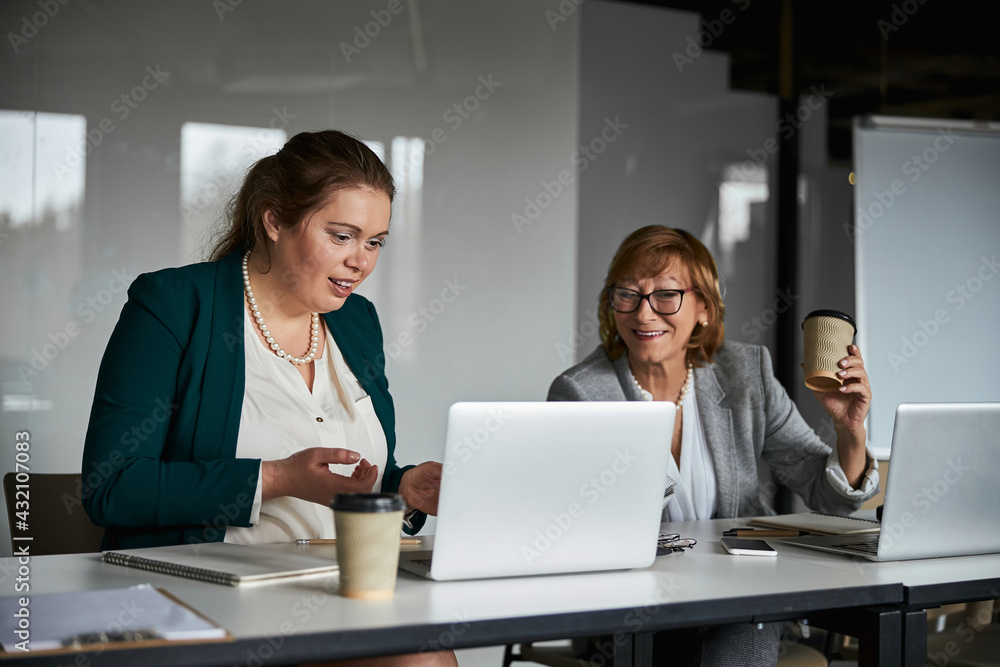 Confused woman learning laptop data with business lady help Confused woman learning laptop data with business lady help
